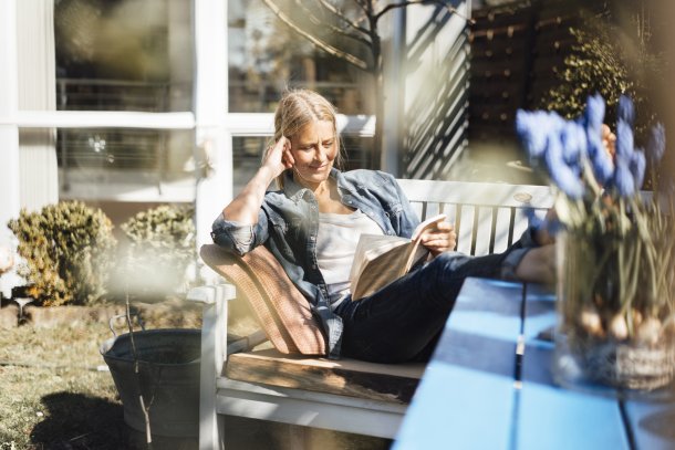 Vrouw leest boek in de tuin