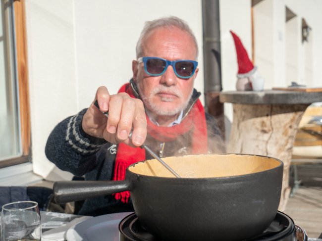 Kaasfondue man aan het eten