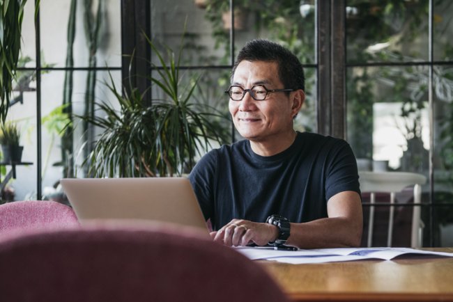 Chinese man zit thuis achter zijn laptop te werken