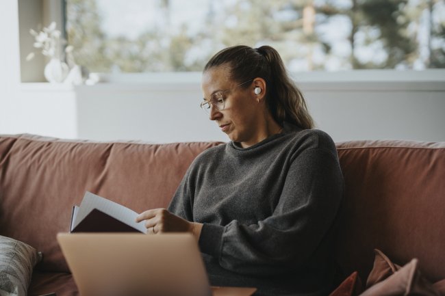 Vrouw met oordopjes op de bank