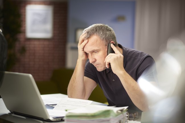 Man zit vertwijfeld aan de telefoon