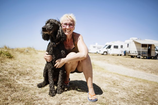 Hond en oudere dame bij een camper in de woestijn