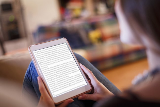 Vrouw leest van roze e-reader