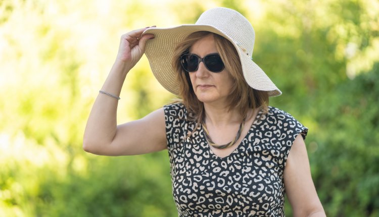 Vrouw met zonnebril en zonnehoed