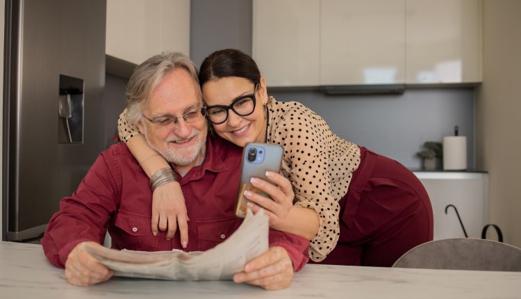 Koppel is bezig met smartphone bekijken in de keuken