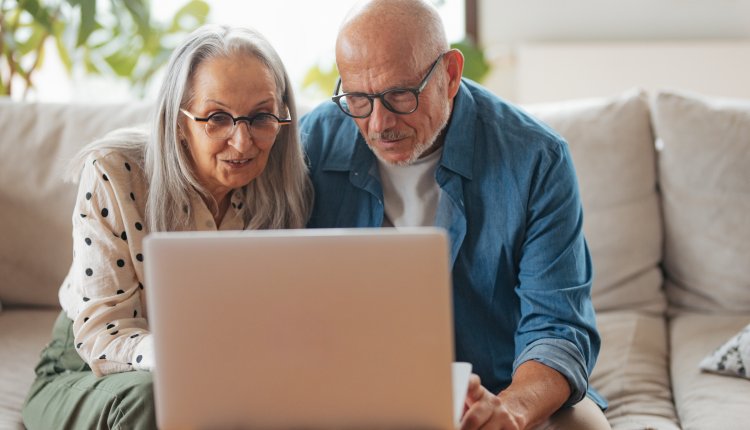 Man en vrouw bestuderen laptop op de bank in de woonkamer