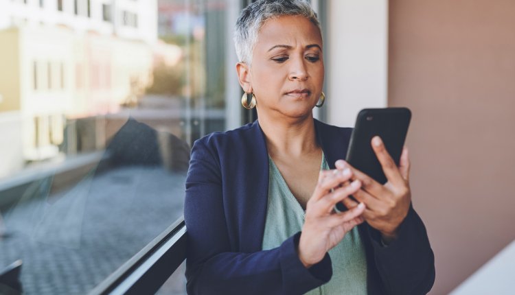 Oudere vrouw checkt telefoon