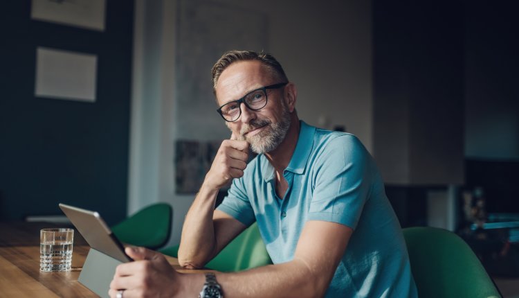 Oudere man aan het werk in zijn studeerkamer, dim licht