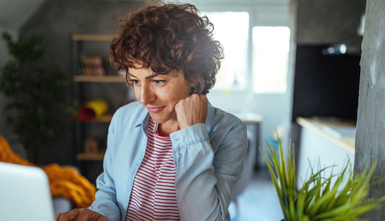 Vrouw in keuken op laptop