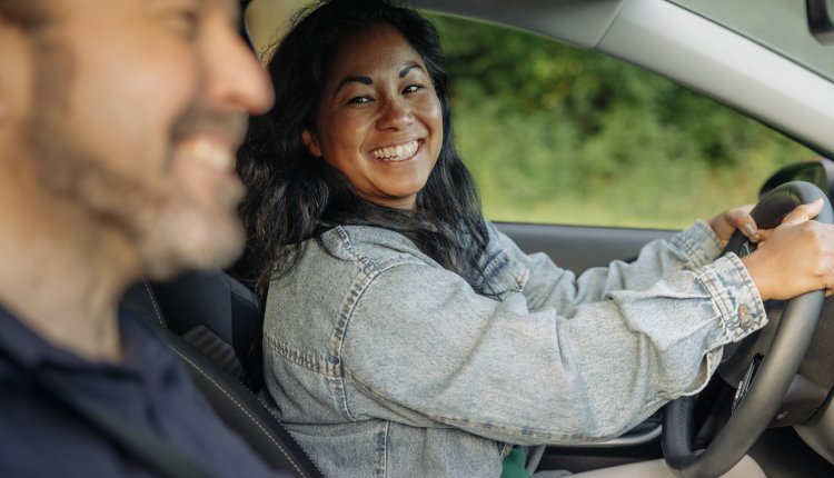 Vrouw achter het stuur met man ernaast in de auto