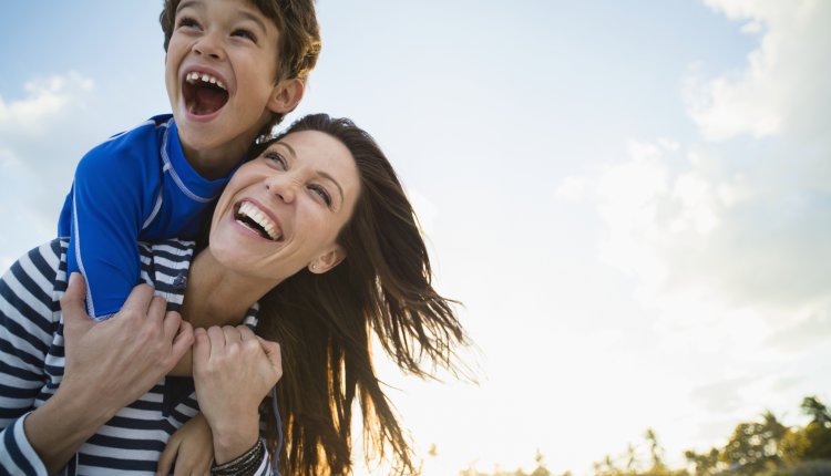 Moeder met zoon op haar schouders