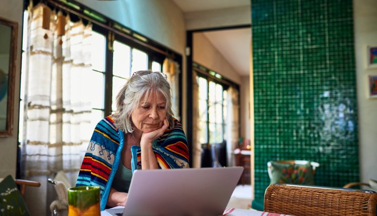 Senior werkt beneden op laptop