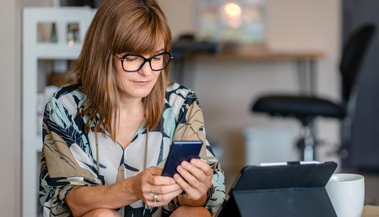 Smartphone vrouw in de keuken