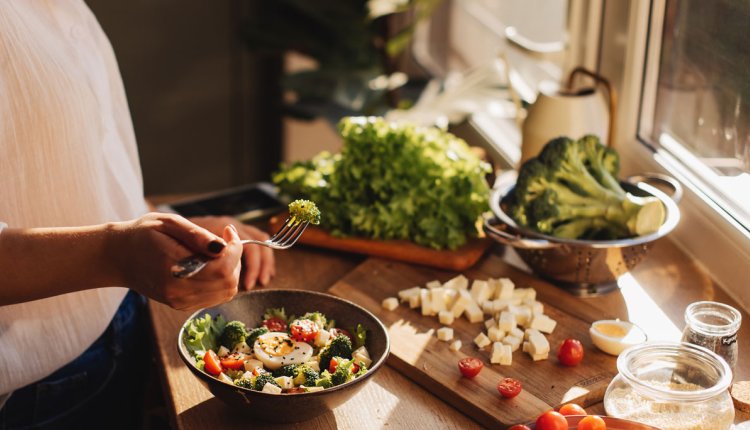 Vrouw in de keuken maakt gezonde maaltijd