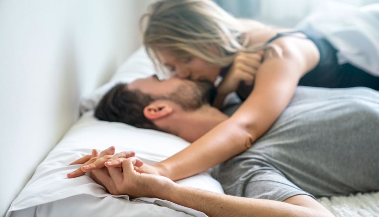 Man en vrouw zoenend in bed