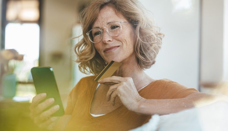 Vrouw betaalt met smartphone en pinpas