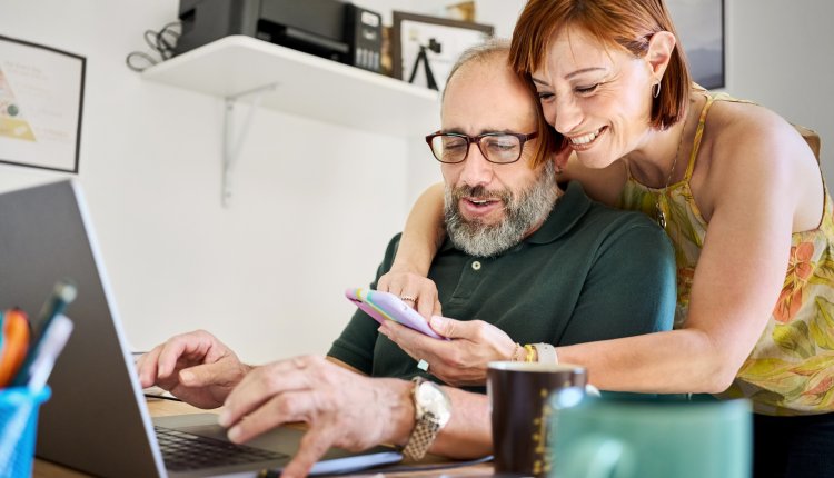 Vrouw en man achter computer en telefoon