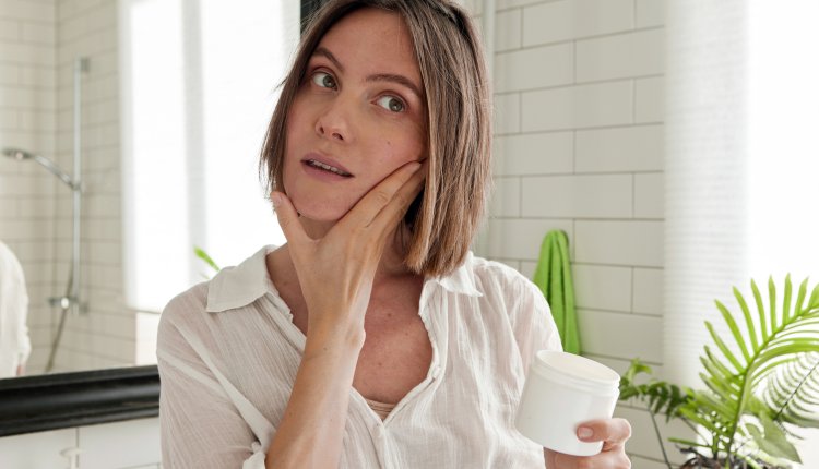 Knappe oudere vrouw kijkt in de spiegel