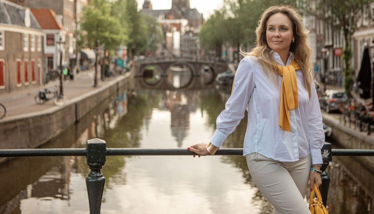 Vrouw op een brug in Amsterdam poserend