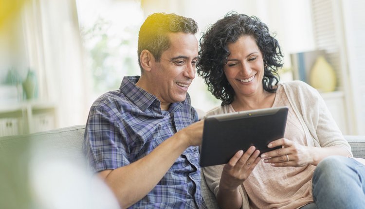 Ouder koppel met tablet op de bank