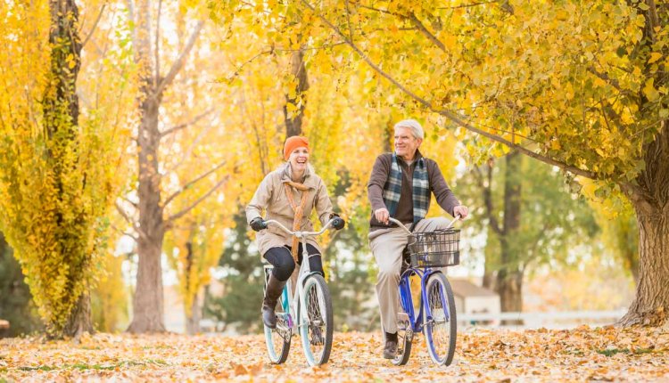 oudere mensen op de fiets in de herfst