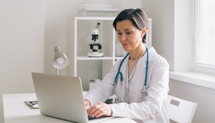 Zorgverzekering vrouw zit achter laptop