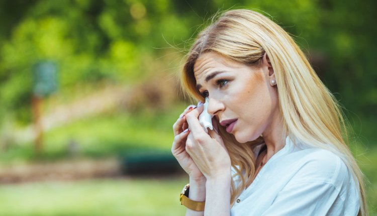 Vrouw dept haar tranen weg met zakdoek