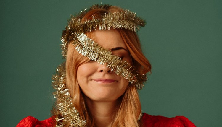 Vrouw met kerstboomslinger om haar hoofd - kerststress?