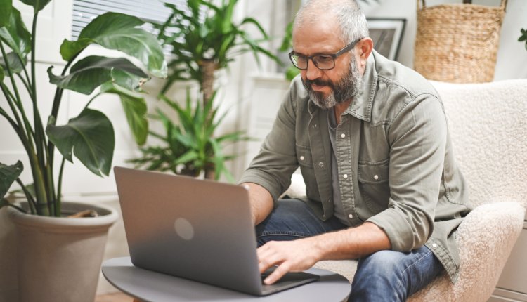 Man doet thuis zijn administratie op laptop