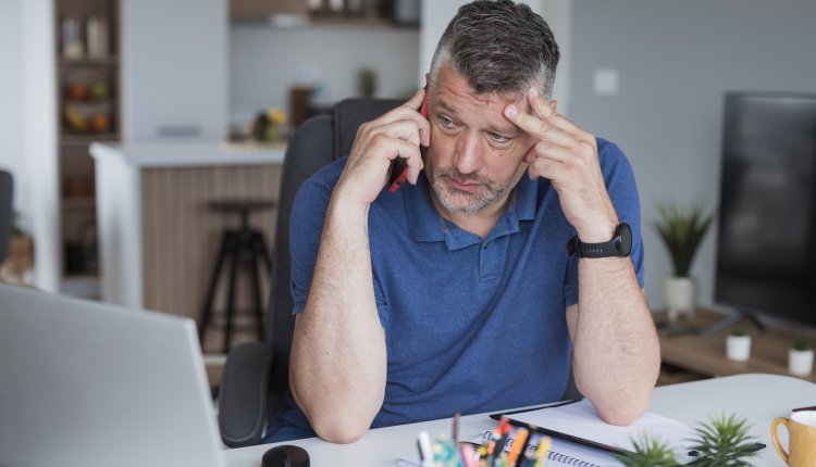 Man kijkt bezorgd tijdens telefoongesprek