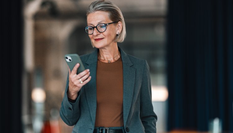 Knappe oudere vrouw met mobiele telefoon