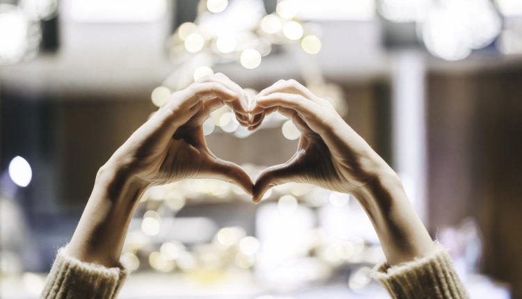 Vrouw maakt met haar handen een hartvorm