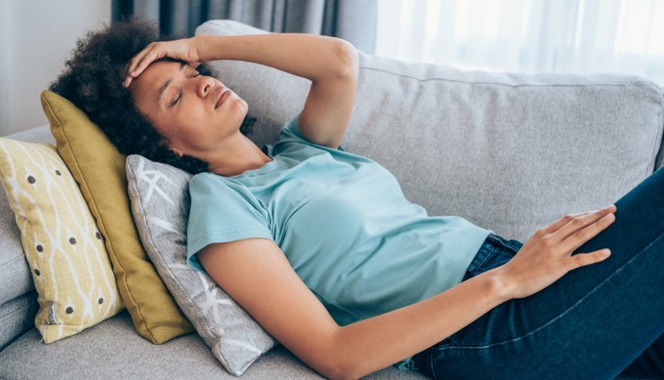 vrouw ligt moe op de bank