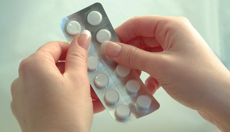 Vrouw drukt tabletten uit pillenstrip paracetamol