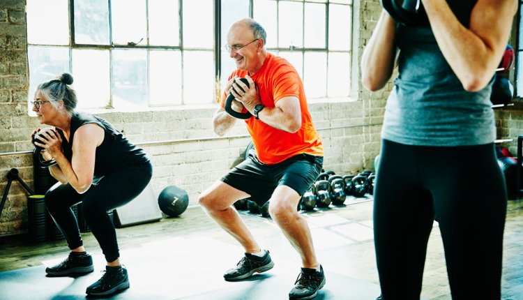 Man en vrouw doen squats met kettlebel en trainen om sterker te worden