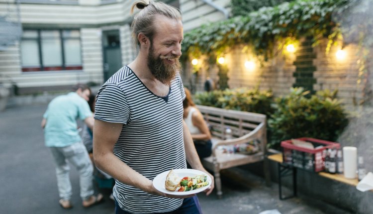 Hippie met man-bun lacht op een vegan barbecue