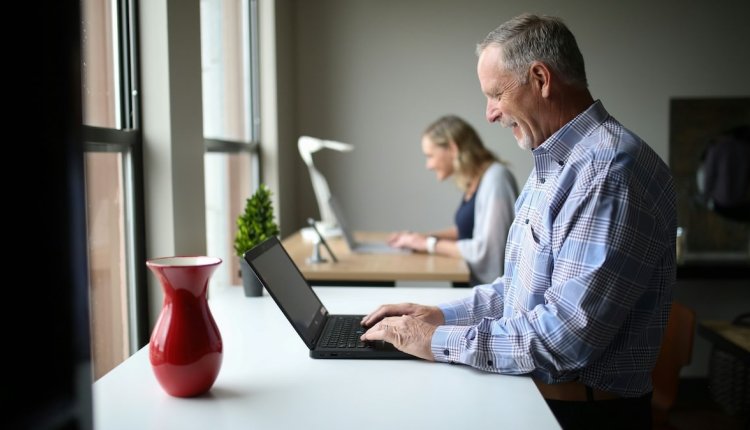 Een oudere man op zijn laptop aan het werk