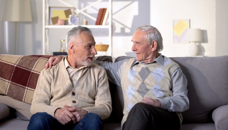 Oudere broers zijn met elkaar in gesprek op een bank in de woonkamer