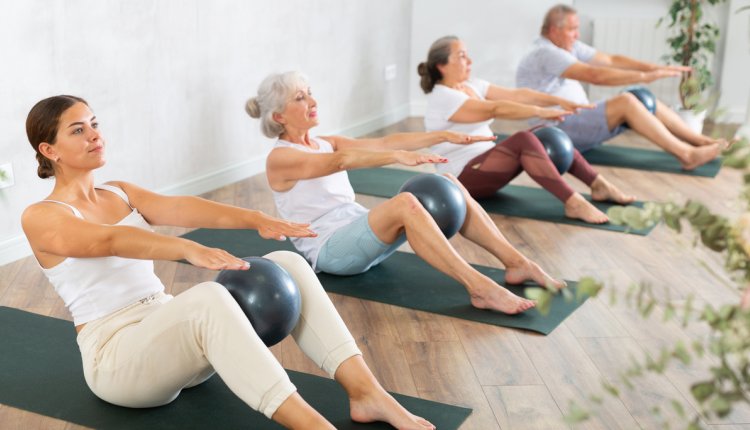 Deelnemers aan een groepsles pilates met een bal