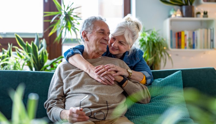 Ouder koppel knuffelt samen op de bank