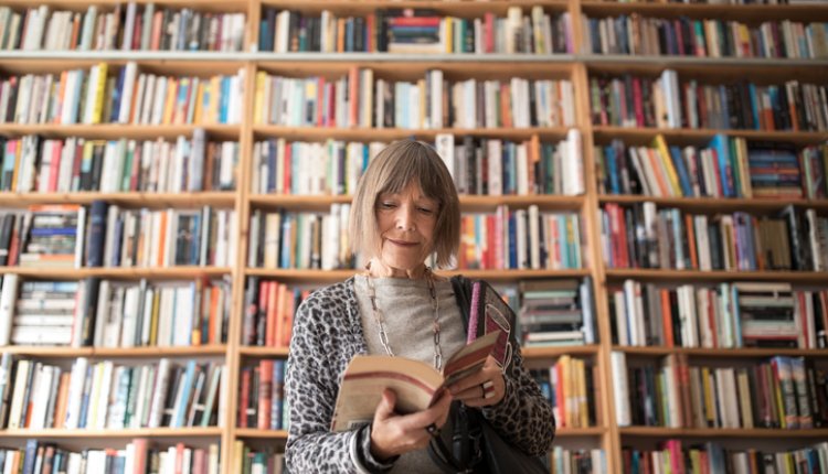 Vrouw in een bibliotheek vol boeken