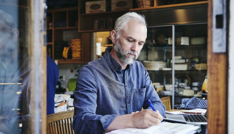 Man is bezig met schrijven in zijn workshop