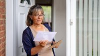 Vrouw opent brief bij de voordeur