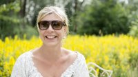 Vrouw met hooikoorts in veld vol bloemen