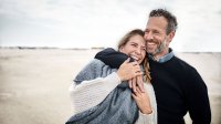 Vrolijk koppel op het strand met wat kouder weer