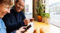 Senior koppel in cafe met smartphone