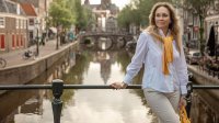 Vrouw op een brug in Amsterdam poserend