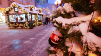 Een sfeervolle kerstmarkt met verlichte kraampjes, sneeuwbedekte takken en kerstdecoraties op de voorgrond