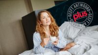 Vrouw wordt wakker met kop koffie op bed