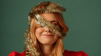 Vrouw met kerstboomslinger om haar hoofd - kerststress?